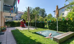 Spielplatz mit Spielturm, Rutsche und Sandkasten im Garten der Kinderkrippe Schmetterlingsbaum | © max ott www.d-design.de